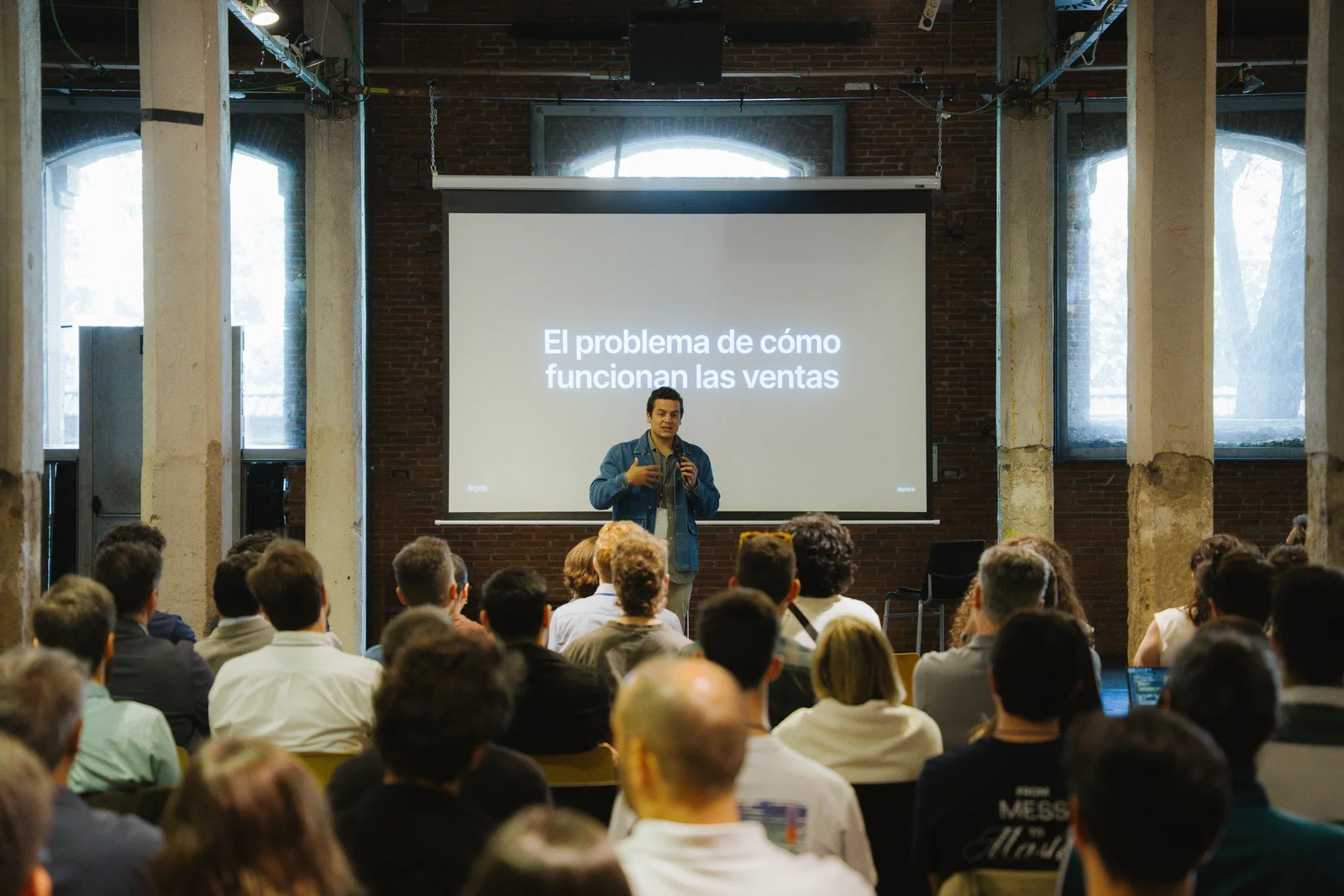 Sala completa durante o segmento de vendas com diapositivo: El problema de cómo funcionan las ventas