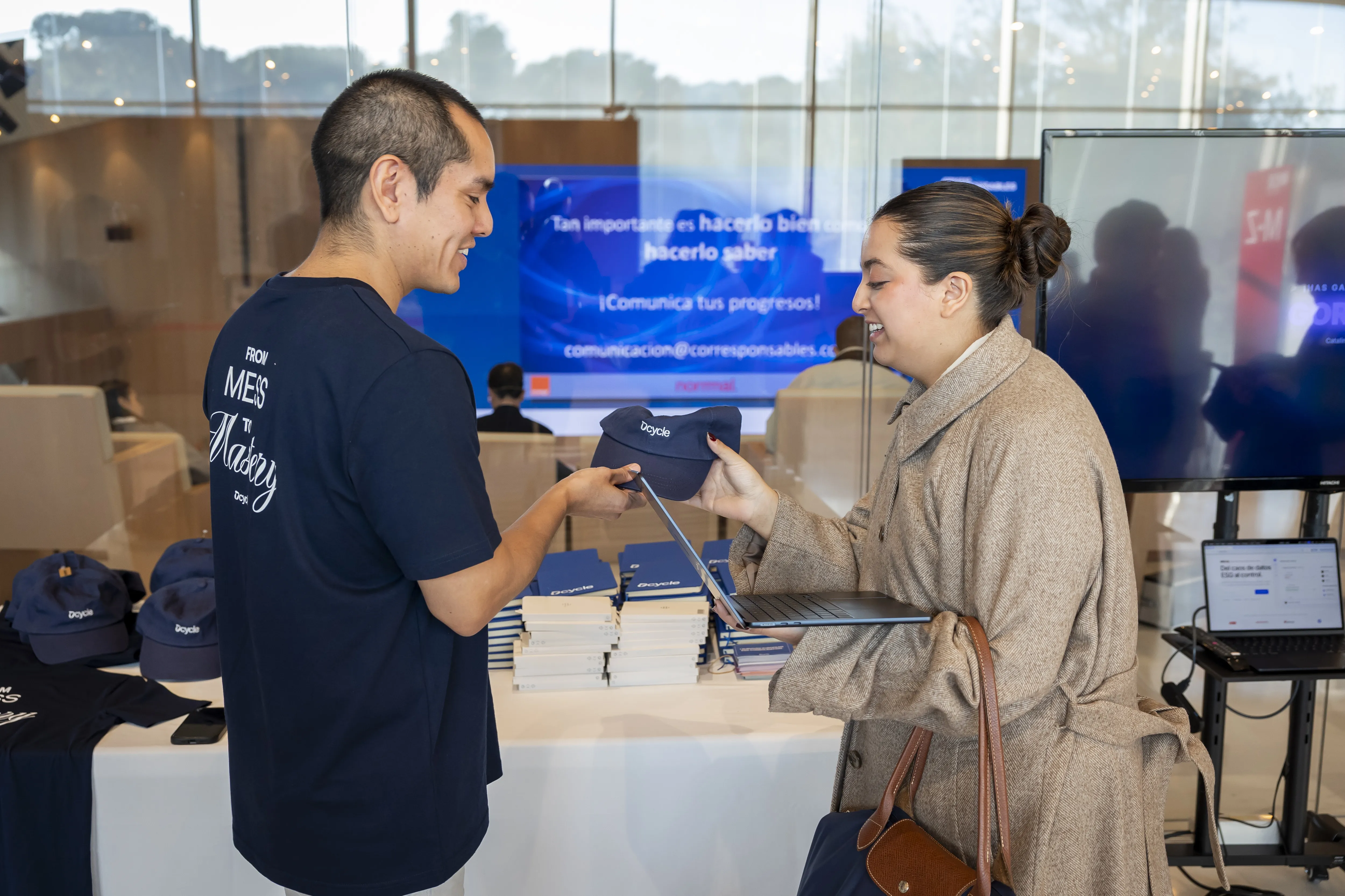 Dcycle team member handing a branded cap to an attendee at the booth